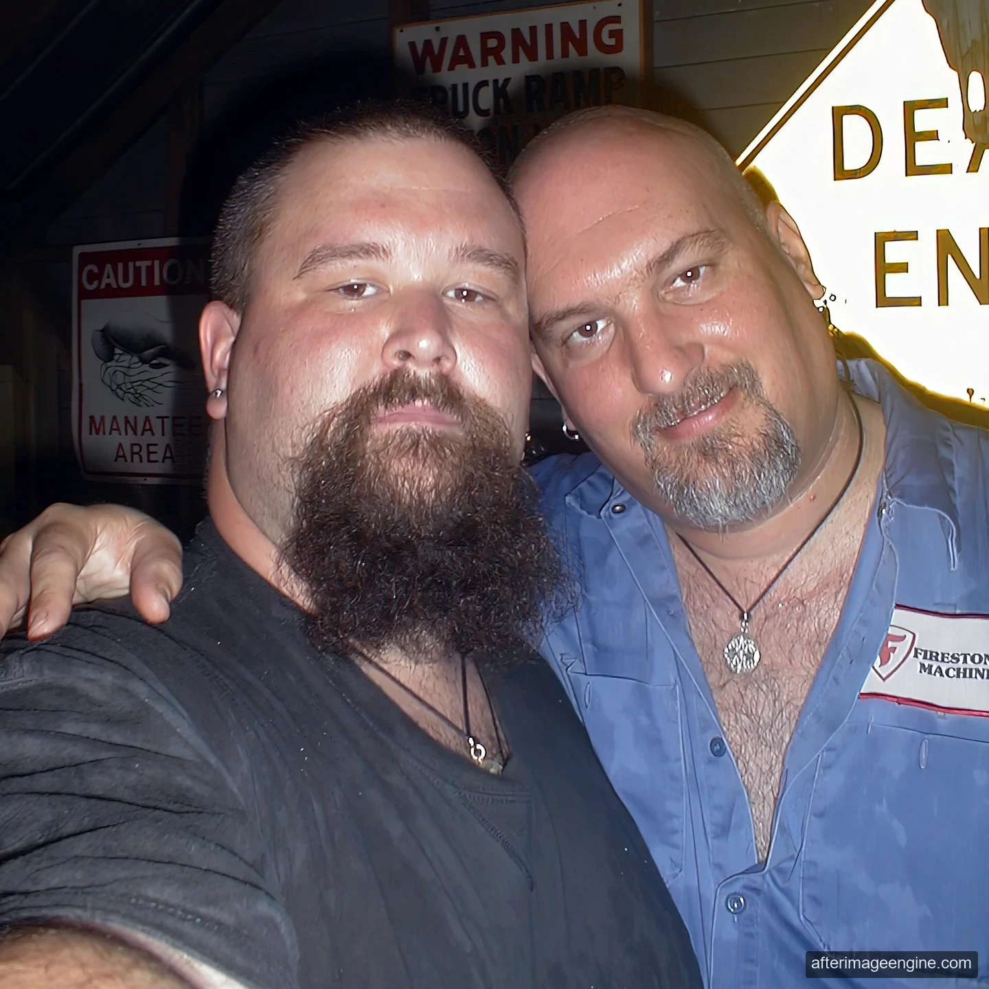 Two men pose close together; a partly visible DEAD END sign appears behind them.